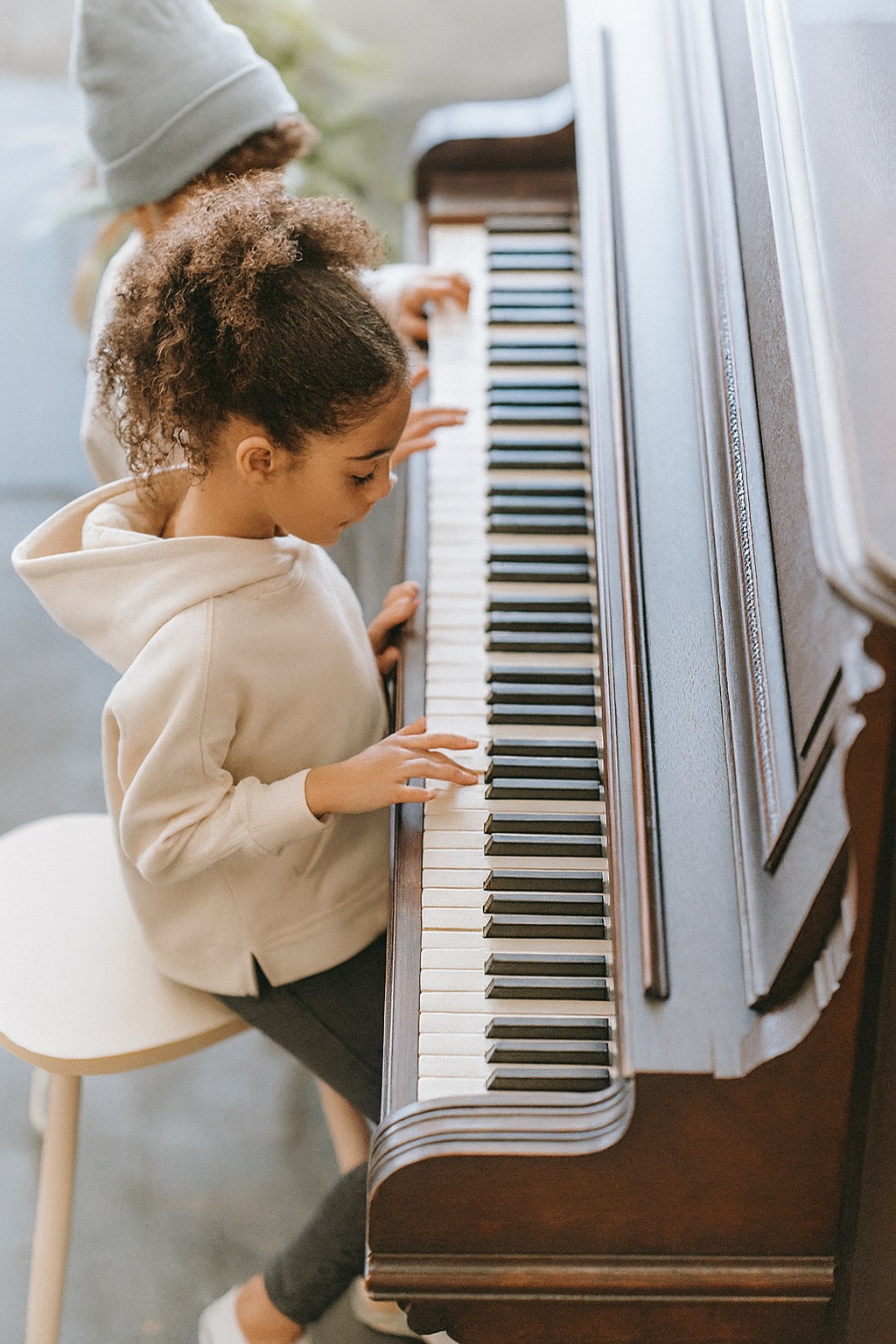 zwei Kinder spielen an einem Piano